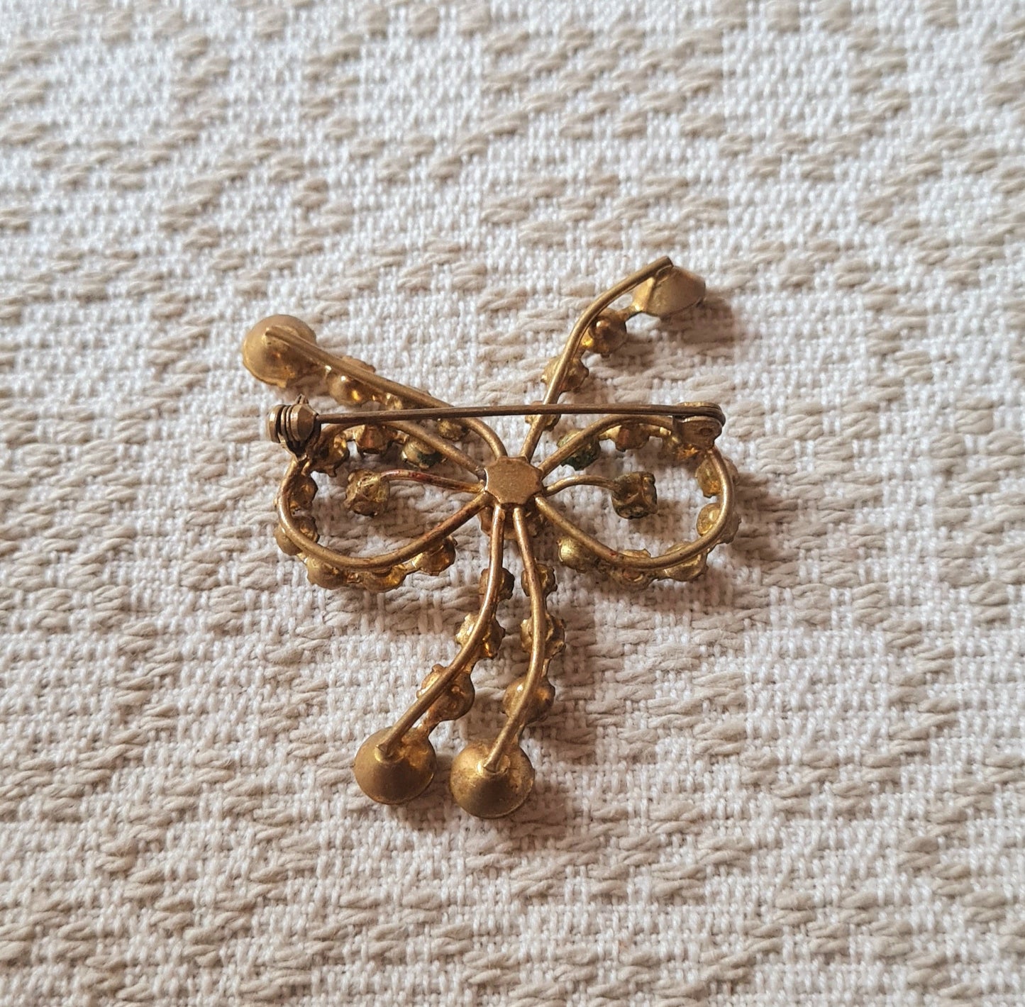 Spilla vintage inglese a fiocco, pietre marroni e montatura dorata