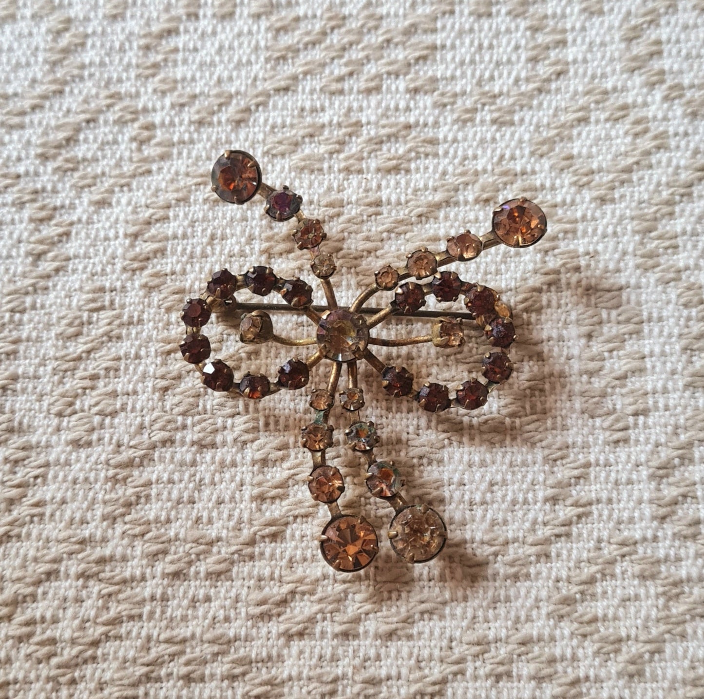 Spilla vintage inglese a fiocco, pietre marroni e montatura dorata