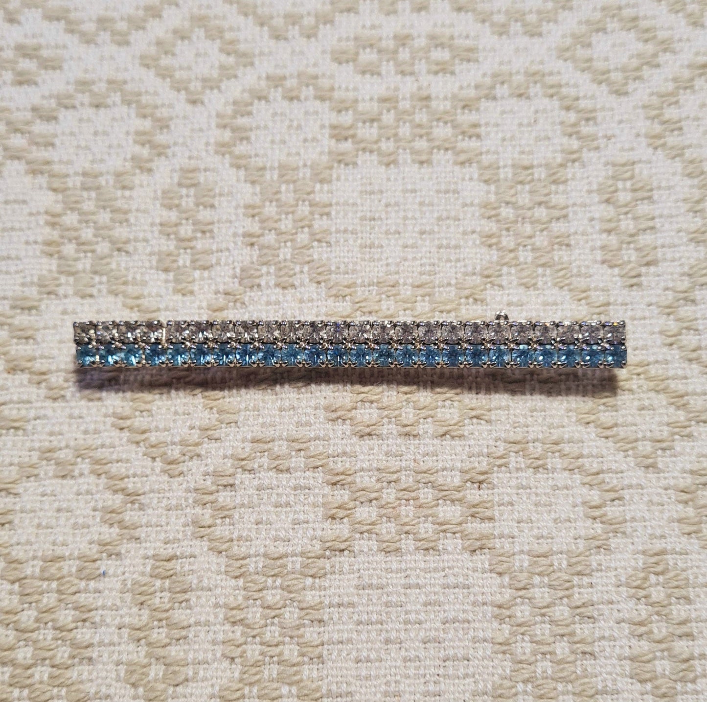 Spilla con pietre azzurre e bianche montatura color argento elegante e raffinata